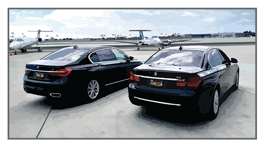 Two black BMW cars are sitting on the runway of a private airport.